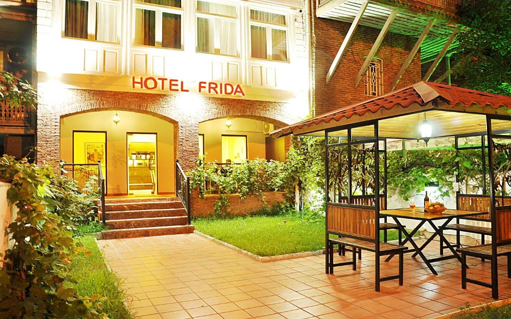 un hôtel avec une table et des chaises devant un bâtiment dans l'établissement Hotel Frida, à Tbilissi