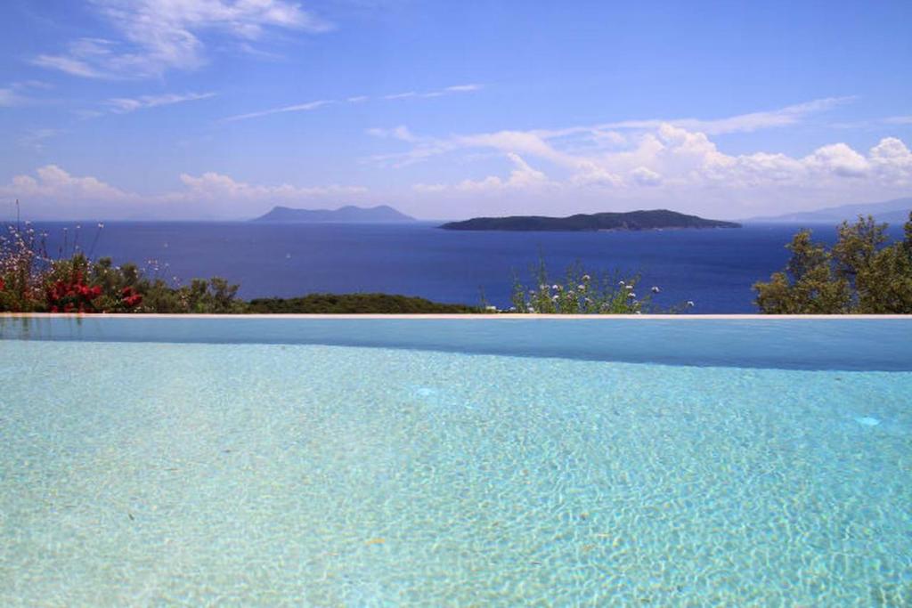 a large swimming pool with a view of the ocean at Villa Koumaria in Sivota