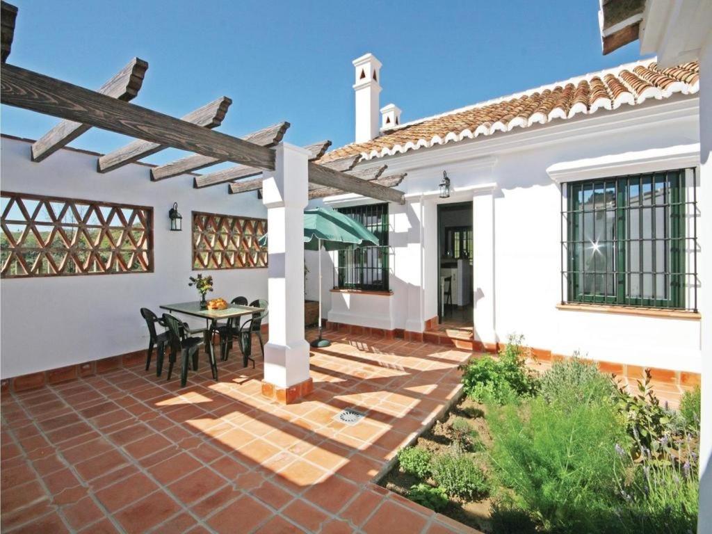 un patio al aire libre con mesa y sillas en Rosas Cantares. Casa Julia en Pizarra