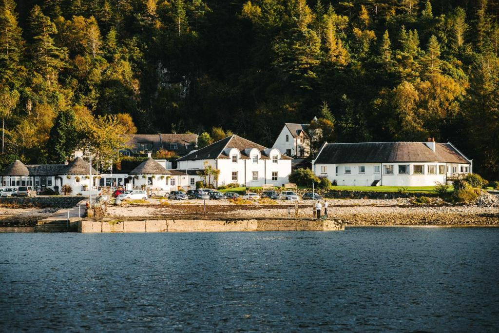 um grupo de casas na costa de uma massa de água em The Pierhouse Hotel em Port Appin