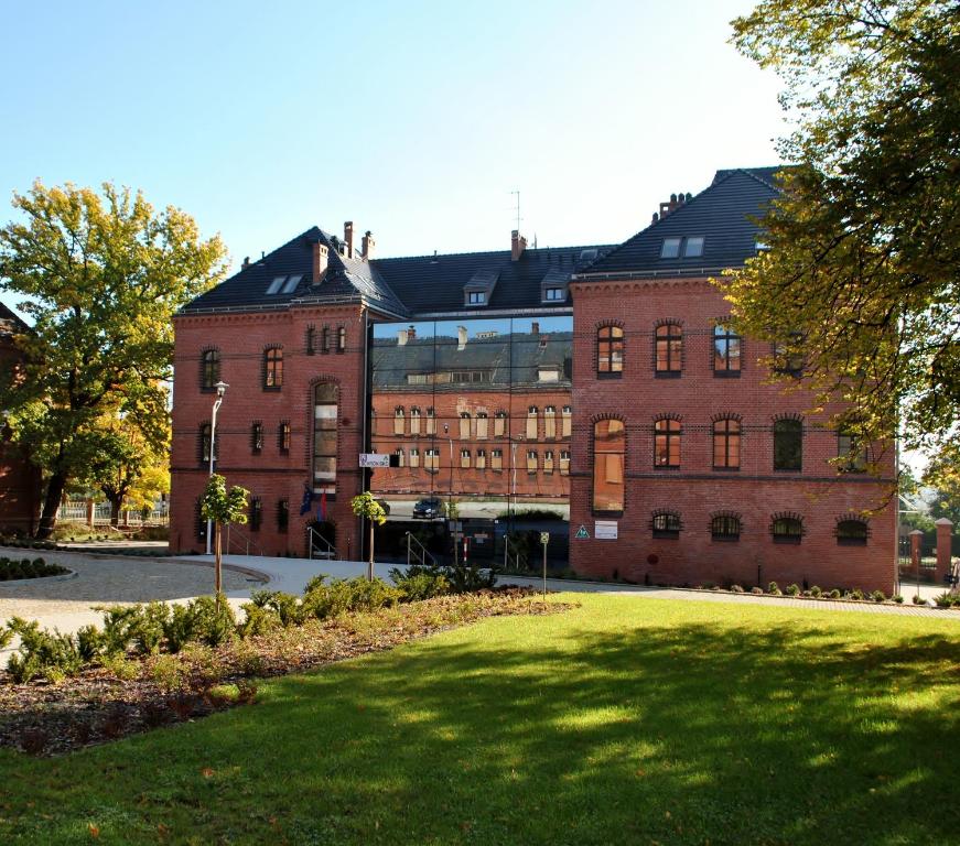 a large brick building with a lawn in front of it at Szkolne Schronisko Młodzieżowe Dąbrówka in Prudnik