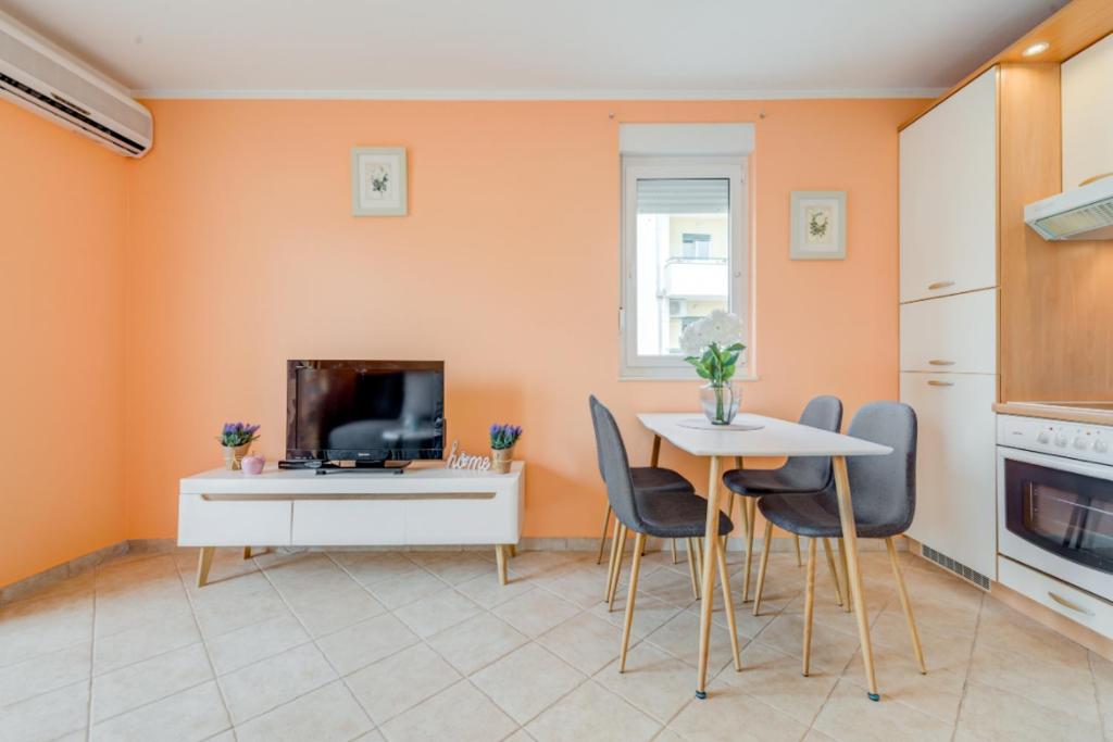 - une cuisine aux murs orange avec une table et des chaises dans l'établissement The best OLD TOWN view apartment, 5 min walk, parking (2+2), à Trogir