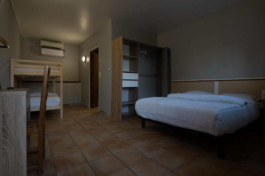 a bedroom with two bunk beds and a tiled floor at Dortoirs Rocade 2 in Pamiers