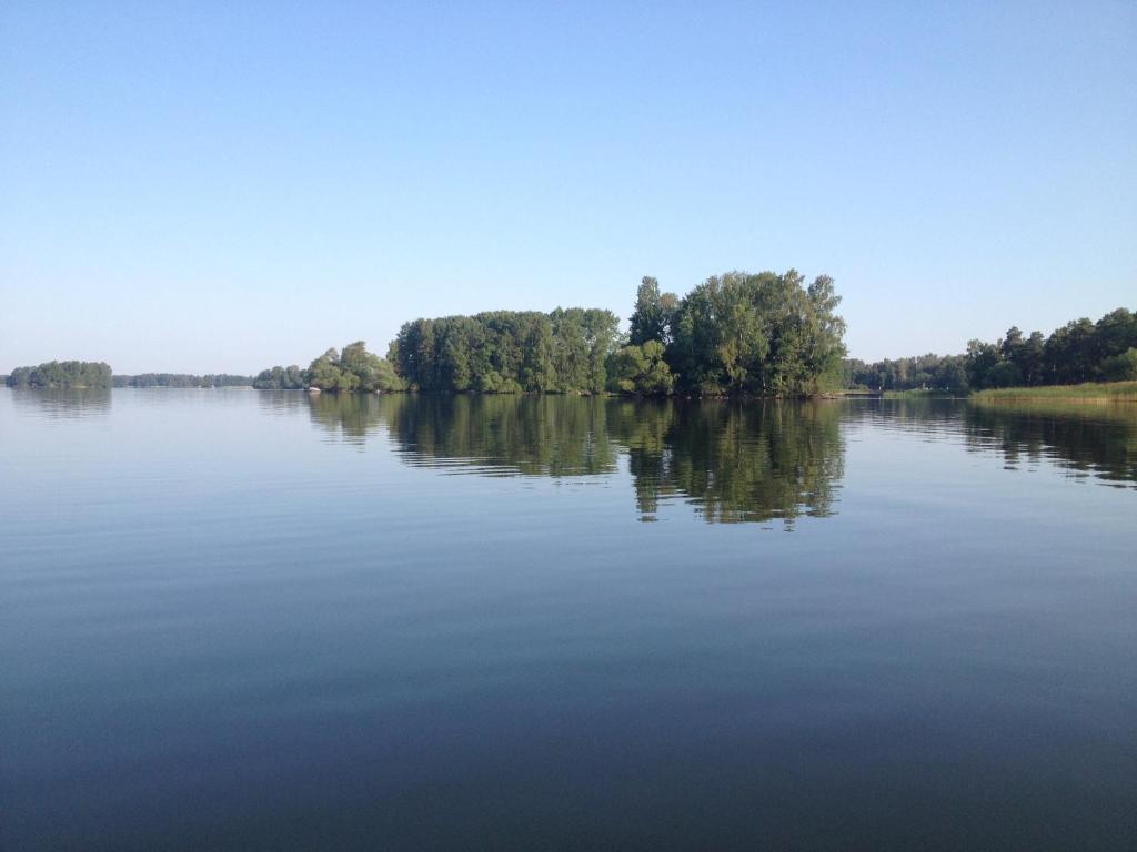 een uitzicht op een meer met bomen aan de oever bij Herrfallet in Arboga