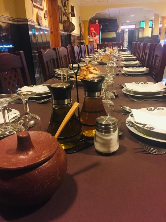 a long table with plates and glasses on it at Hotel Sonia Chipude in El Cercado