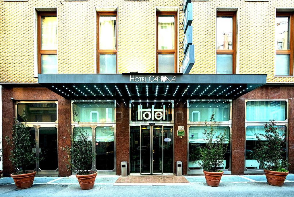 a hotel with potted plants in front of a building at Canova Hotel in Milan