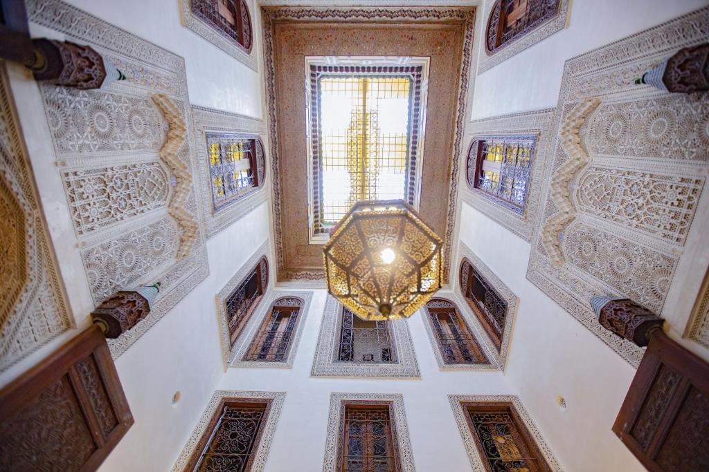 um corredor com um lustre num edifício em Dar Settash em Fez