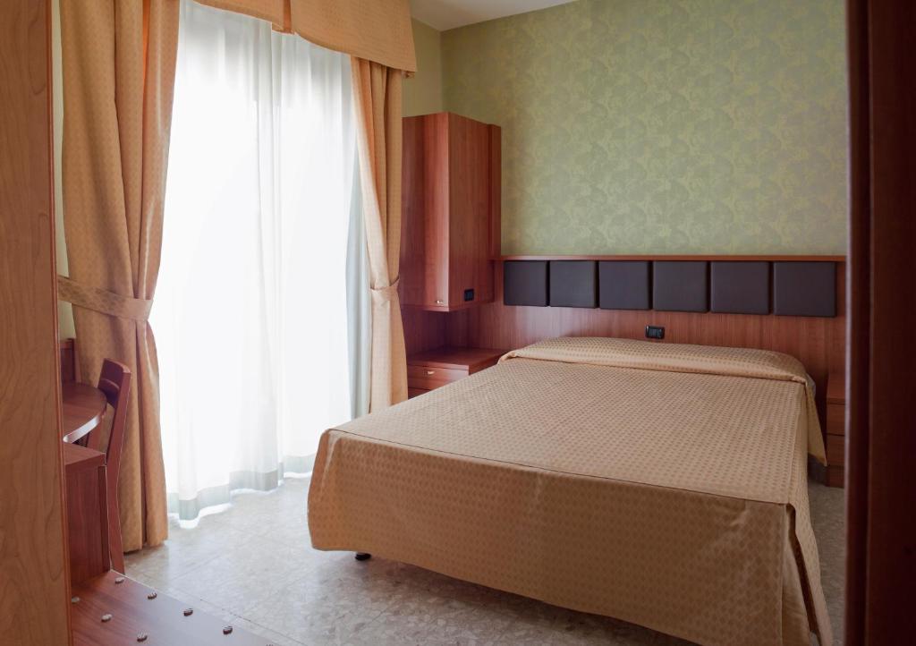 a bedroom with a bed and a large window at La Lanterna in Silvi Marina