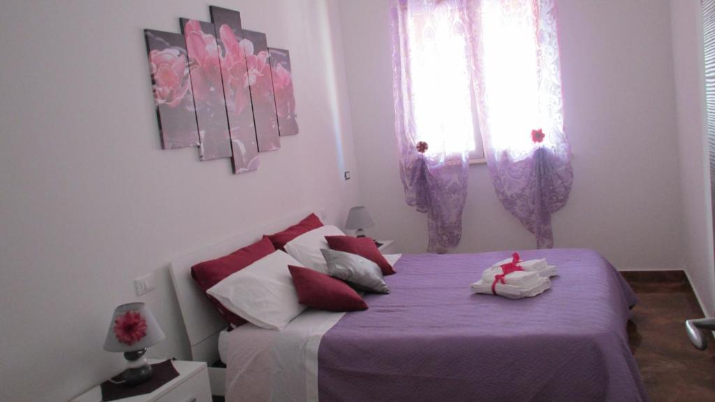 バレストラーテにあるAppartamento MANILAのベッドルーム1室(紫のシーツが敷かれたベッド1台、窓付)