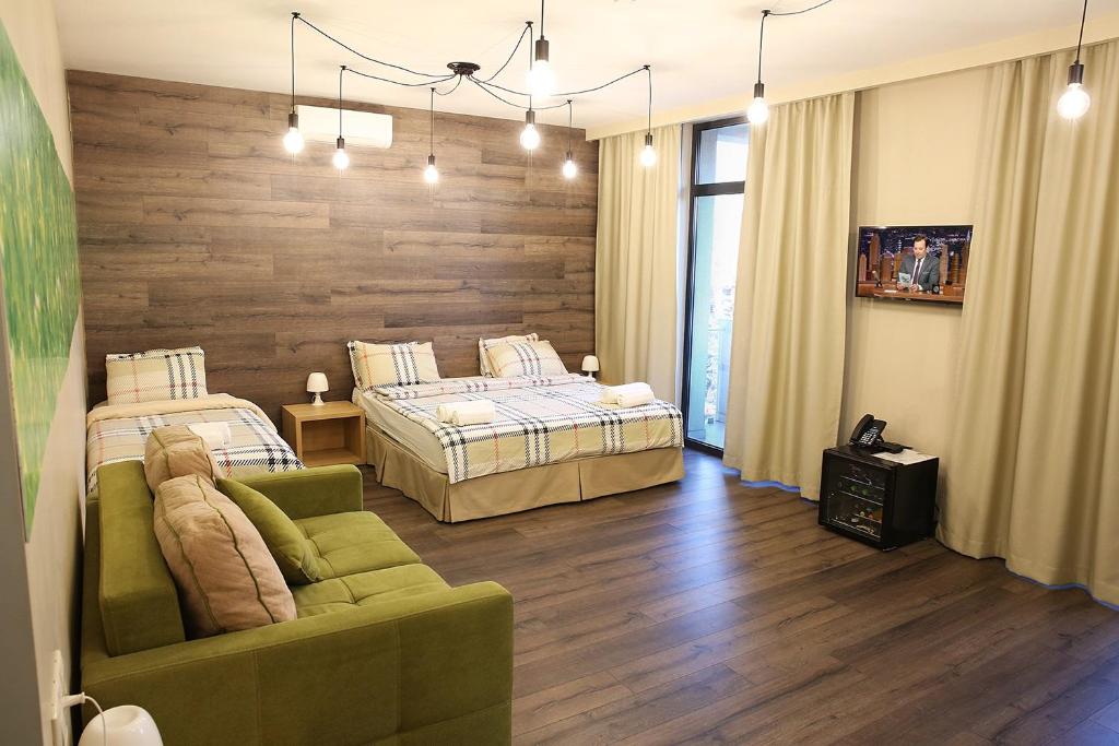 a hotel room with two beds and a couch at Wine Hotel Chisinau in Chişinău