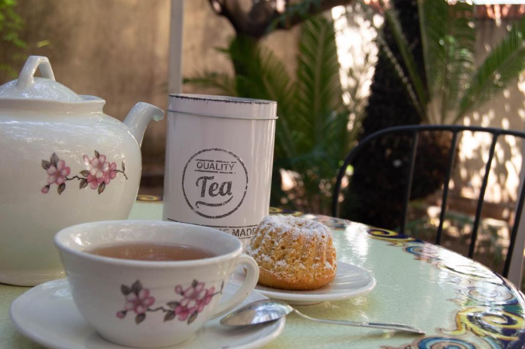 eine Tasse Tee und ein Donut auf dem Tisch in der Unterkunft A Casa di Nonna Emma in Santa Croce Camerina