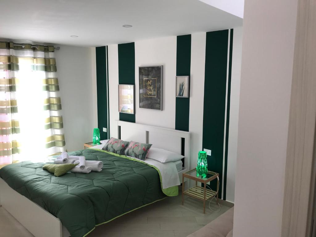1 dormitorio con 1 cama con rayas verdes y blancas en centruMassimo b&b, en Palermo