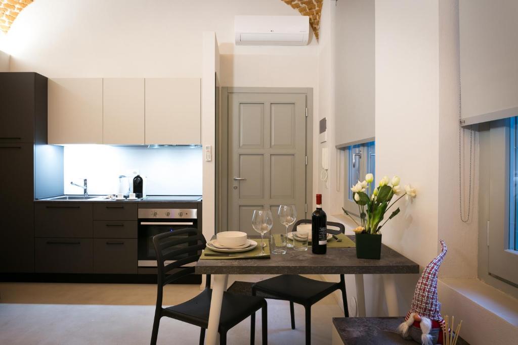 uma cozinha e sala de jantar com mesa e cadeiras em Mameli Comfort em Casale Monferrato
