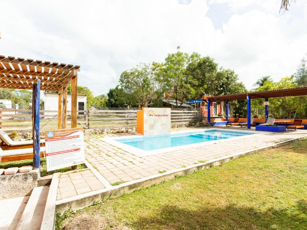 a swimming pool in a yard with a pavilion at Hotel Hacienda Bacalar in Bacalar