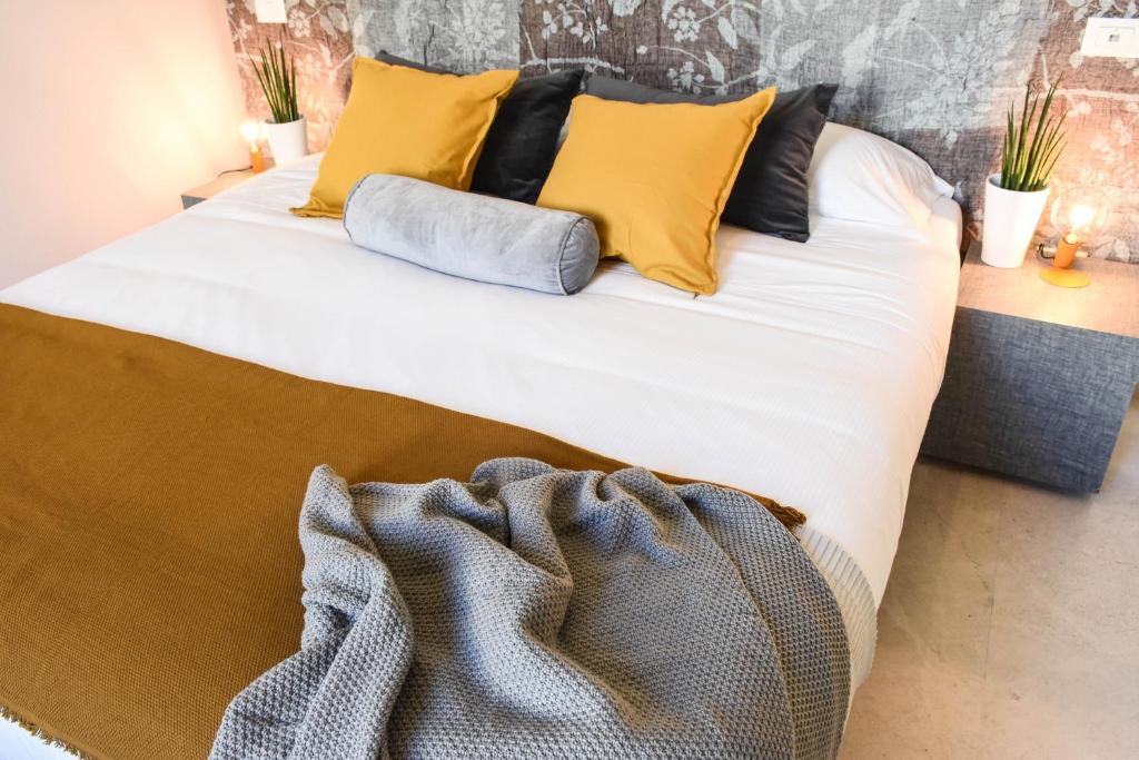 a bed with yellow pillows and a blanket on it at Garibaldi23 Rooms in La Spezia