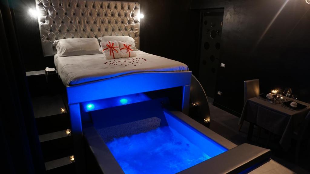 Schlafzimmer mit einem Bett und einer blauen Badewanne in der Unterkunft Il Cantuccio Suite in Salsomaggiore Terme