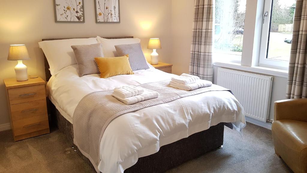 a bedroom with a bed with two towels on it at 23 Hedgefield House in Inverness