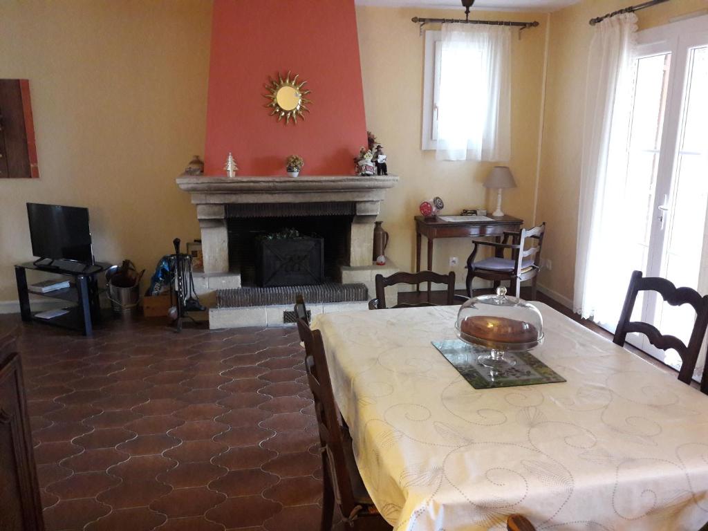 a living room with a table and a fireplace at VILLA LA LURETTE, appartement et studio in Saint-Étienne-les-Orgues