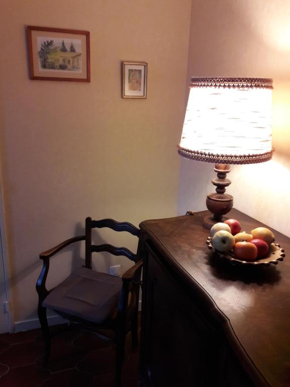 a table with a lamp and a bowl of fruit on it at VILLA LA LURETTE, appartement et studio in Saint-Étienne-les-Orgues