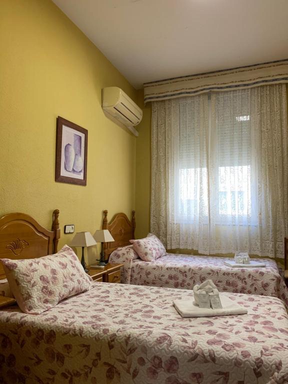 a hotel room with two beds and a window at Hostal Internacional in Madrid