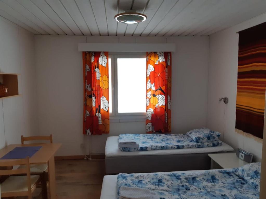 a room with two beds and a window at Matkakoti, Motel Kieppi Kuhmo in Kuhmo