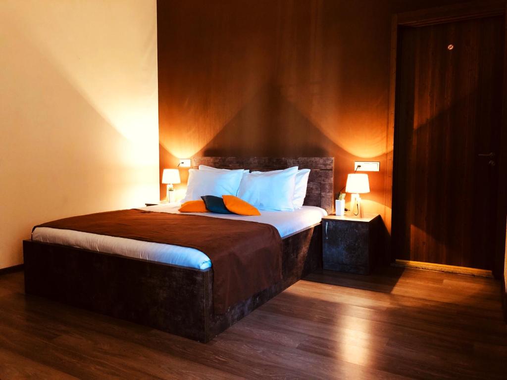 1 dormitorio con 1 cama grande y 2 lámparas. en Hotel Nabadi en Tiflis