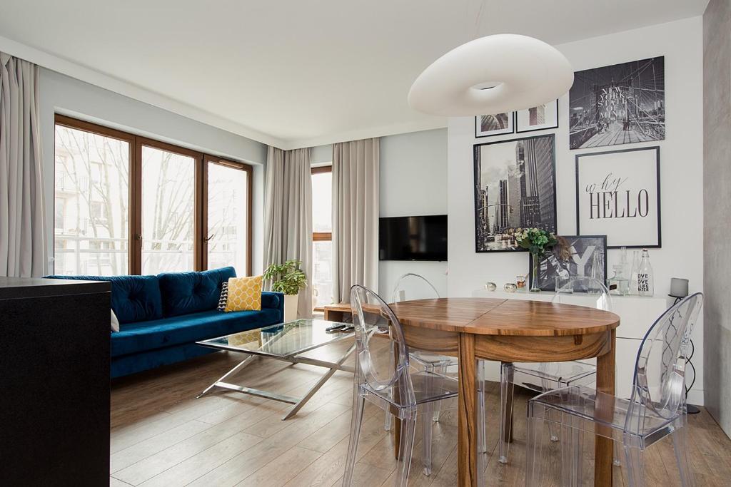 a living room with a table and a blue couch at Woronicza Premium in Warsaw