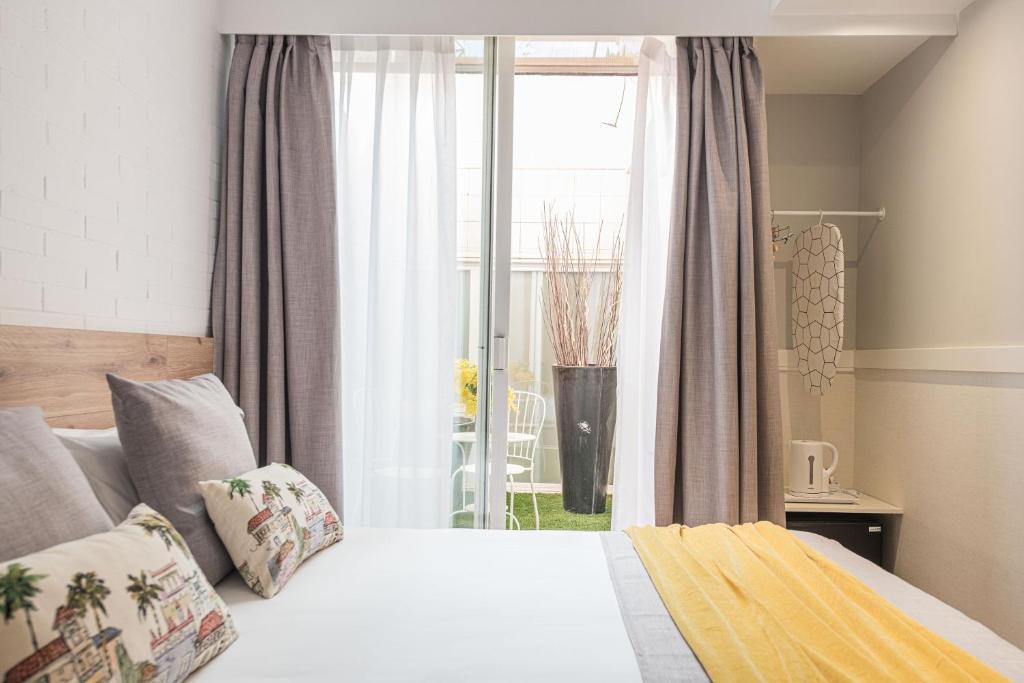 Schlafzimmer mit einem Bett vor einem Fenster in der Unterkunft BYPILLOW House in Barcelona