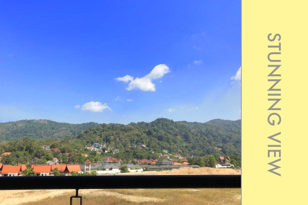a view of a town with mountains in the background at Stylish Condo Stunning Views in Kamala Beach