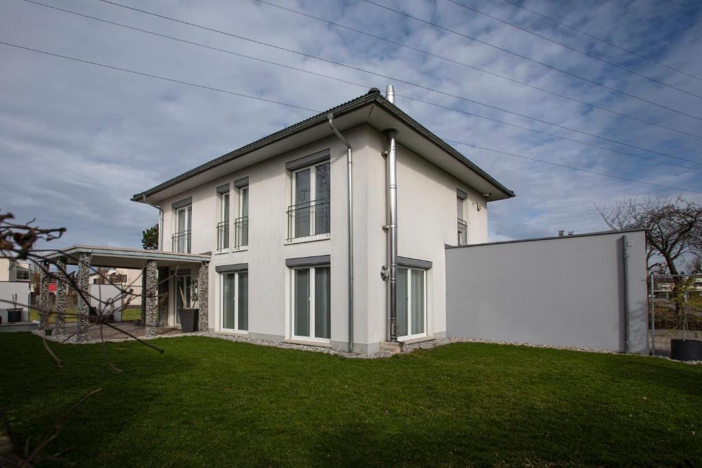 uma casa branca com uma grande parede branca em Tolles Einfamilienhaus nahe dem Bodensee em Lauterach