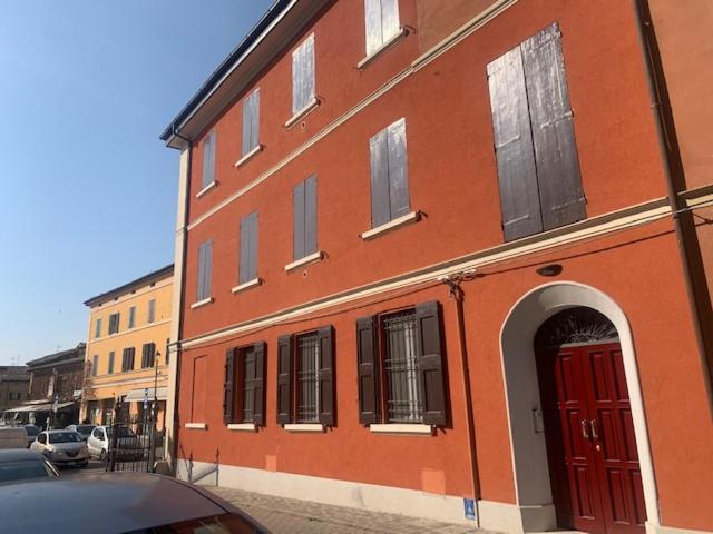 un edificio rojo con una puerta roja en una calle en Le case di Chiara, en San Pietro in Casale