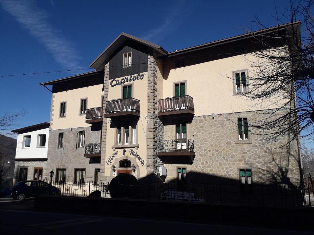 un gran edificio blanco con balcones. en Albergo Capriolo, en Sestola