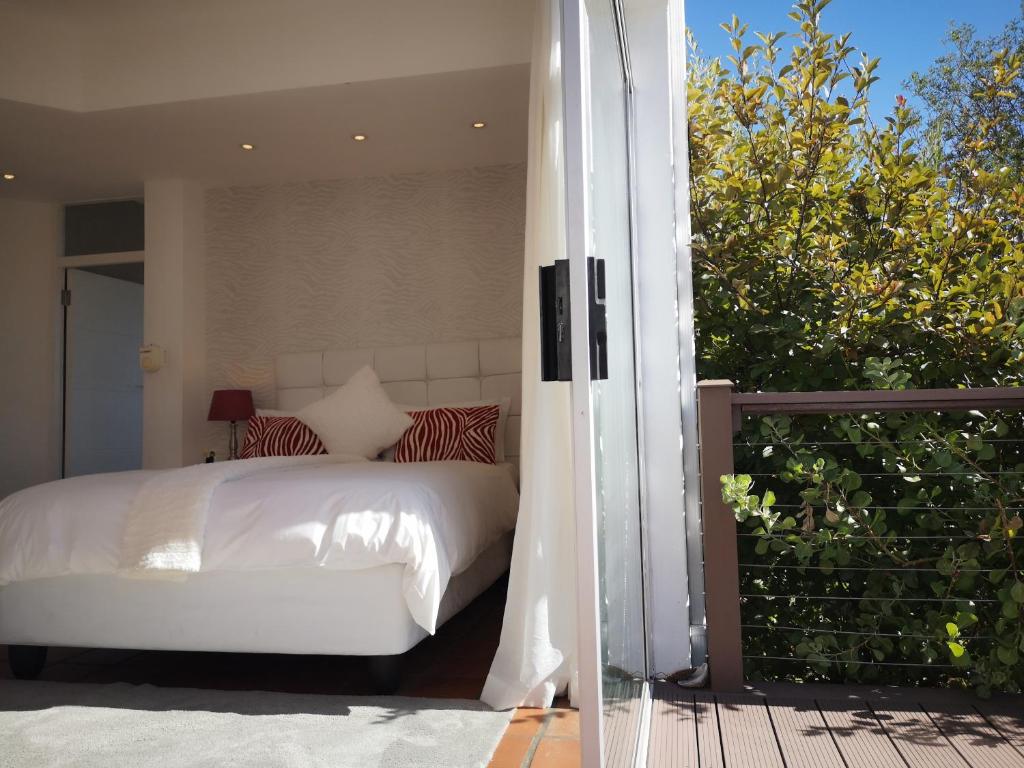 a bedroom with a white bed on a balcony at Diamond House Guesthouse in Cape Town