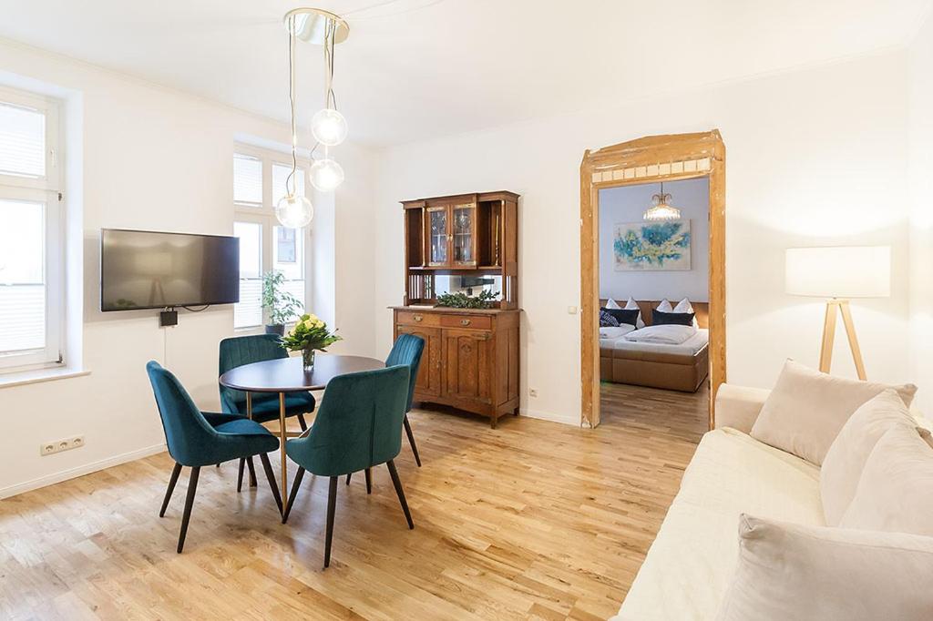 Hotel Auguste Suite No 1 Ruhiges Apartment im Zentrum Leipzig, a living room with a table and chairs and a couch at Auguste Suite No 1 Ruhiges Apartment im Zentrum Leipzig in Leipzig