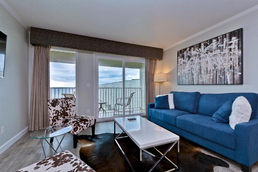 sala de estar con sofá azul y mesa en Fun and Functional Waterfront Condo - Heated Pool - WIFI en Tampa