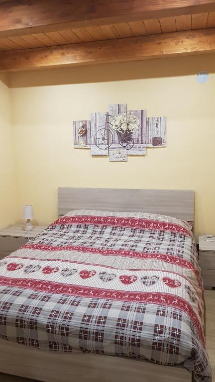 łóżko w sypialni z obrazami na ścianie w obiekcie La Ca' d' Rina Casa Vacanze w mieście Melle