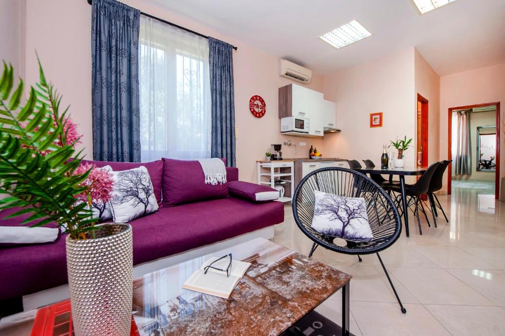 a living room with a purple couch and a table at Rovinj City Apartment in Rovinj