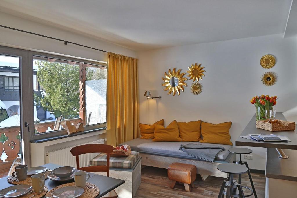 ein Wohnzimmer mit einem Sofa und einem Fenster in der Unterkunft Das Schönanger Ferienwohnungen in Grainau