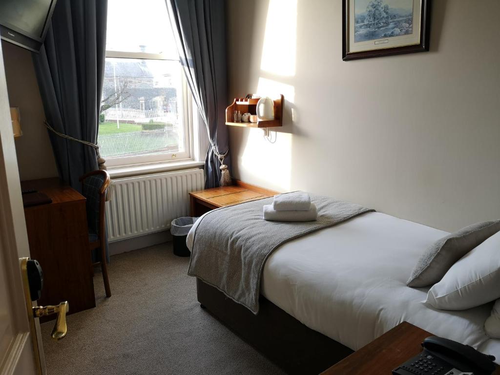 a hotel room with a bed and a window at Glen Gat House in Dundalk