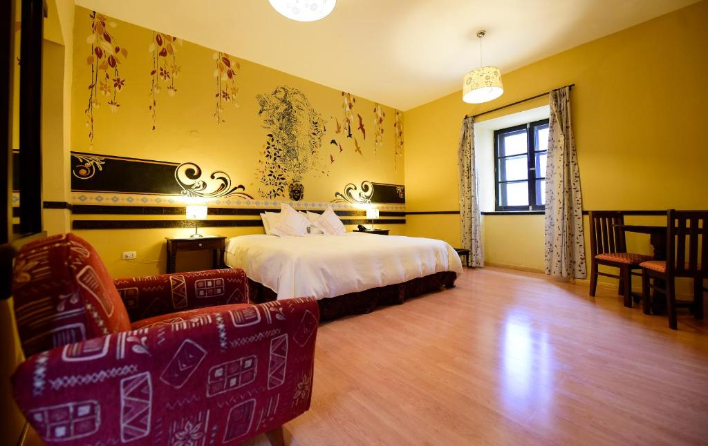 um quarto com uma cama e cadeiras num quarto em Yabar Hotel Plaza em Cusco