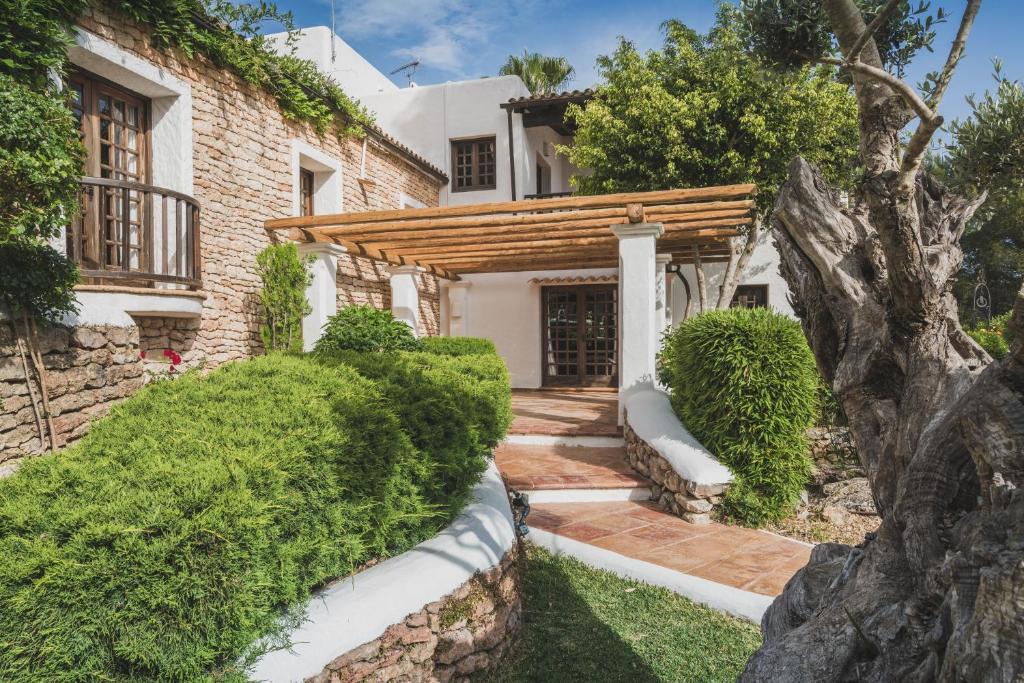 a home with a wooden pergola and a yard at Can Blay in Santa Eularia des Riu