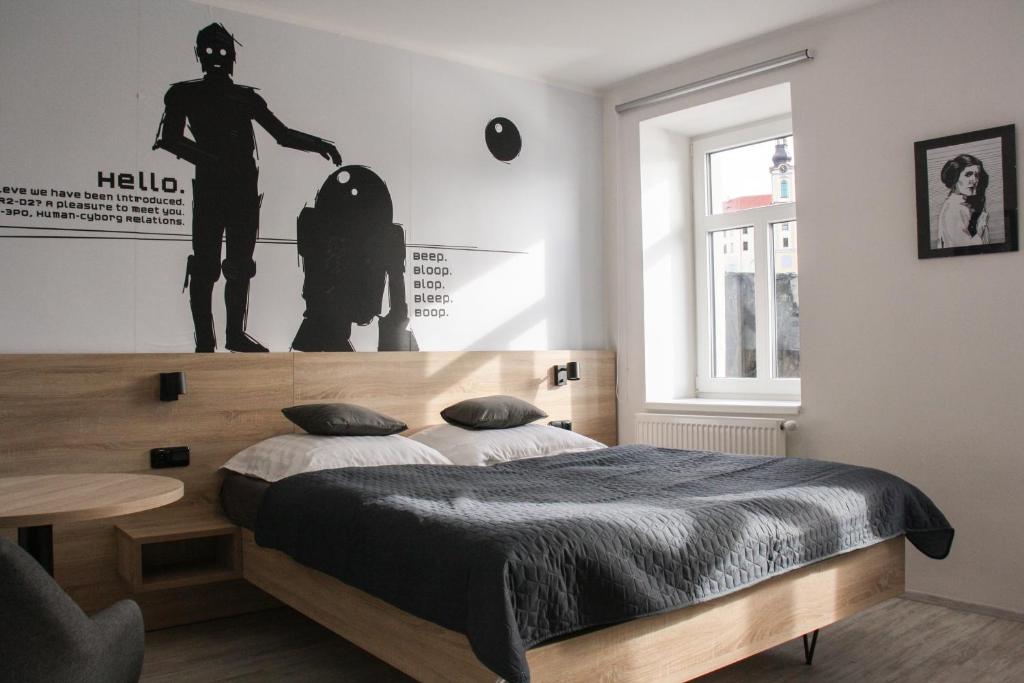 een slaapkamer met een bed met een houten hoofdeinde bij Penzion Via Ferrata in Děčín
