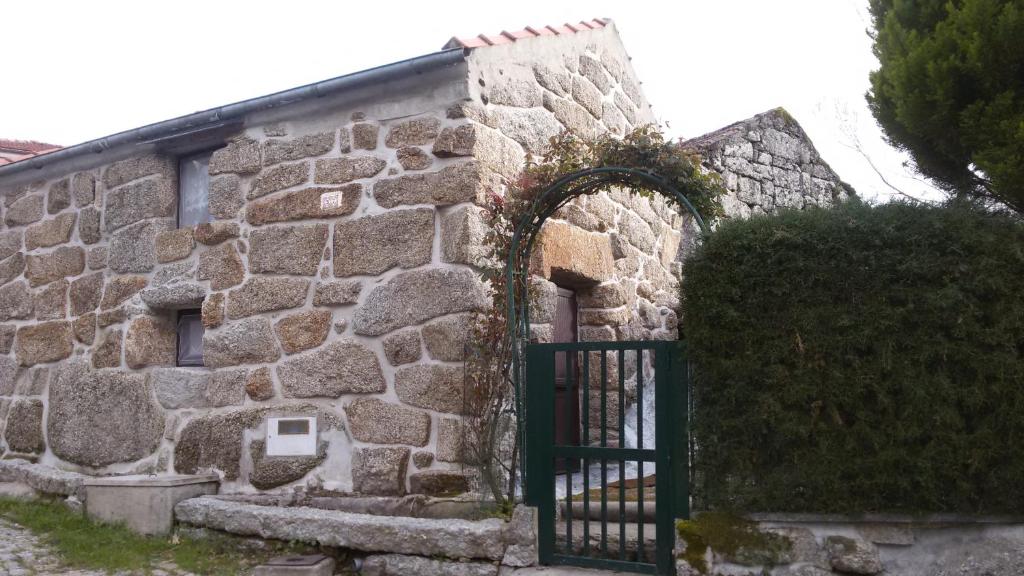 an old stone building with a green gate at Carneiro Country Houses Casa das Batatas in Amarante