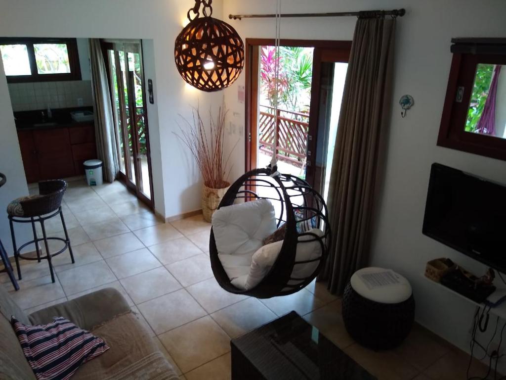 a living room with a swinging chair in a living room at Apto Pipa Beleza Spa Resort in Pipa