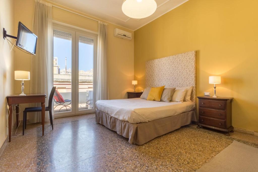 Schlafzimmer mit einem Bett, einem Schreibtisch und einem Fenster in der Unterkunft Al Porto Di Cagliari in Cagliari