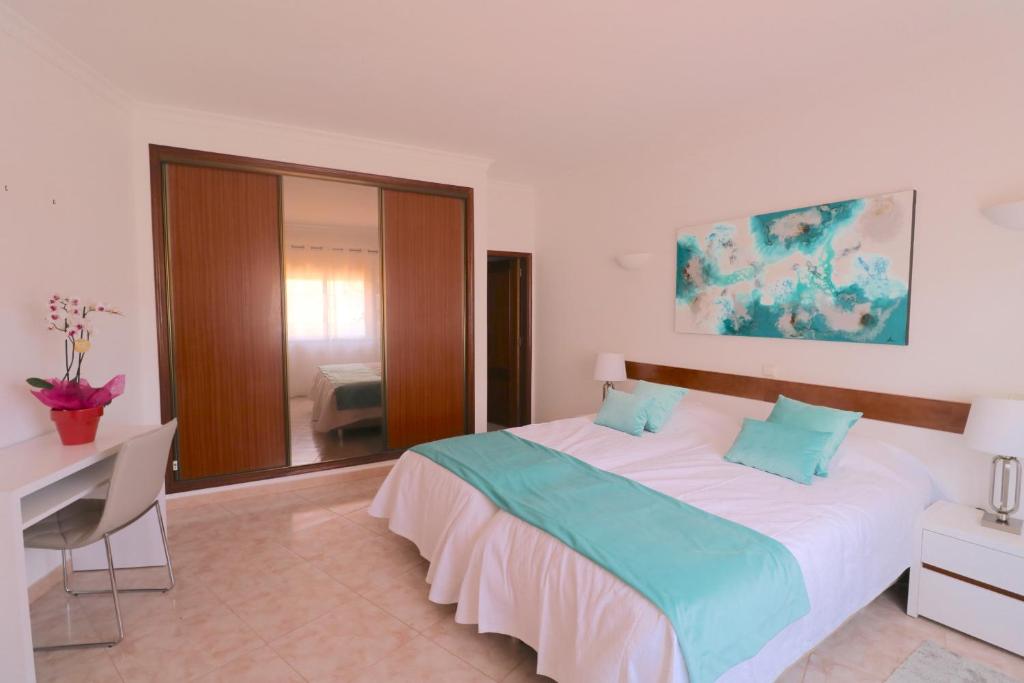 1 dormitorio con cama, escritorio y espejo en Fournier Apartment - Praia da Luz, en Luz