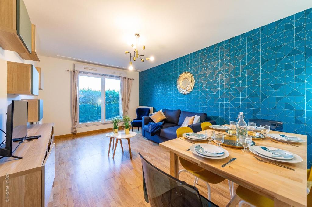 ein Wohnzimmer mit einem Tisch und einer blauen Wand in der Unterkunft The Graphic Condo - Fairytale Factory in Lognes