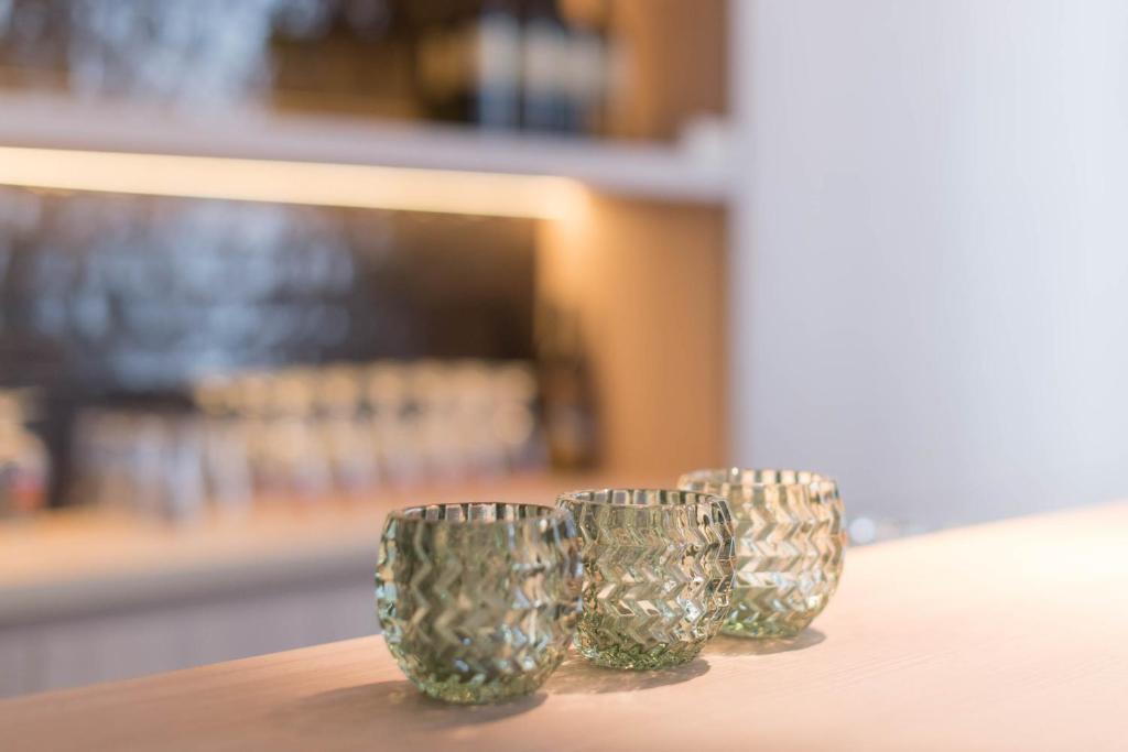 three glass cups sitting on top of a table at Hotel Augustyn Brugge in Bruges