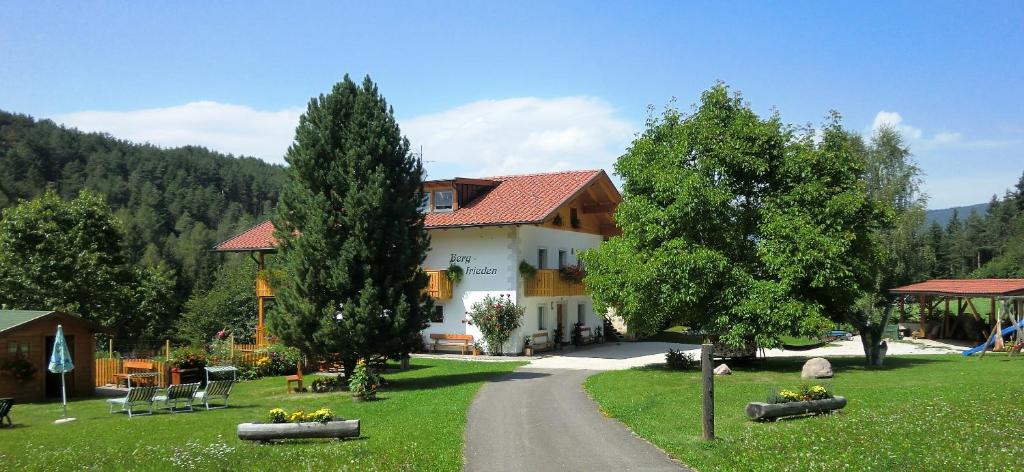 a house with trees and a road in front of it at Haus Bergfrieden in Castelrotto