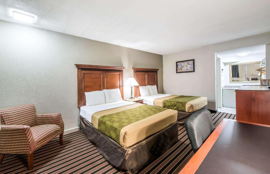 una habitación de hotel con 2 camas y una silla en Rodeway inn St Joseph, en Saint Joseph